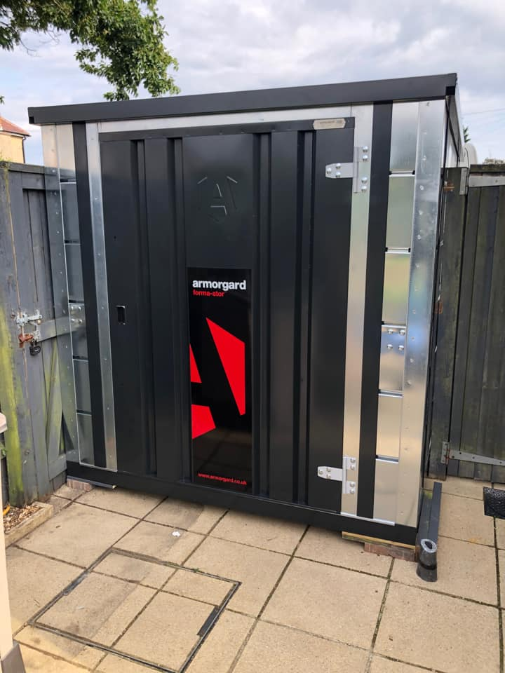 Forma-Stor COSHH is a store used for a hazardous substances. Its a black and silver storage container which appears to be in someones garden.