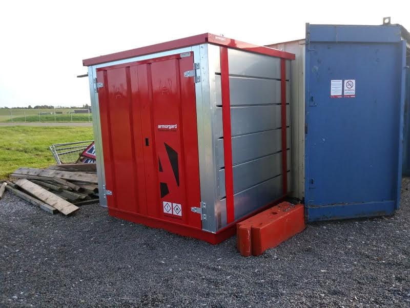 Armorgard FromaStor COSSH used for hazardous goods storage is shown outside with red doors, floor and roof and silver metallic sides