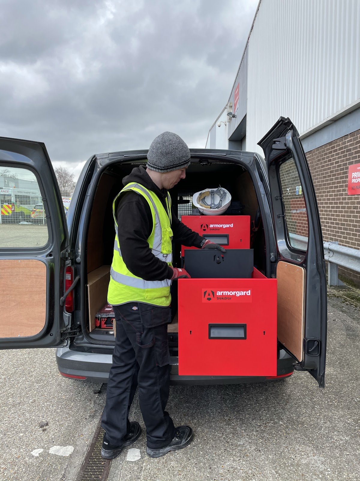 A person in hi vis putting in dividers inside their TrekDror which is in the back of their van