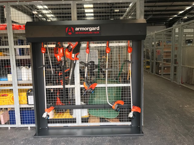 A black strimmersafe rack in a warehouse with strimmers and a leaf blower hanging from the top