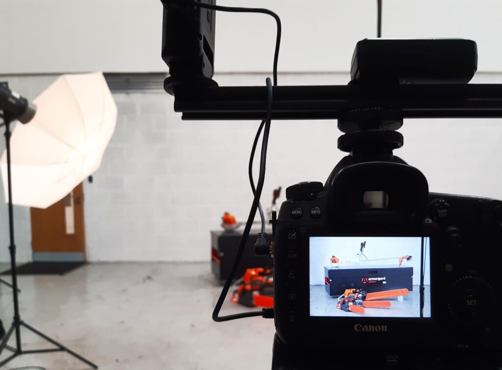 A view of a camera screen about to take an image of 3 chainsaws infront of an Armorgard storage bank in a studio setting