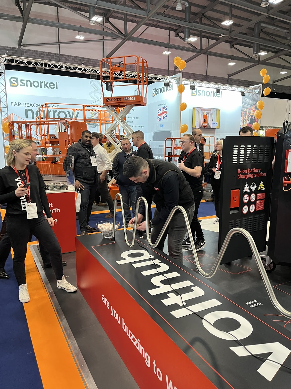 A person playing a buzz wire type game at the Armorgard stand at executive hire show