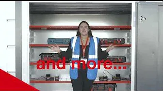 a lady wearing a blue hi vis vest standing the door way of the PowerStor and there is text on the image saying 'and more'