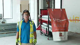 a man wearing a hi vis vest standing in front of a duck rack at a building site