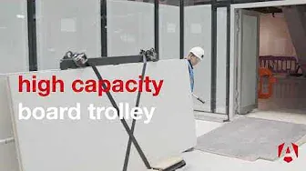A person pulling some boards on a LoadAll through a building site, there text on the image saying high capacity board trolley
