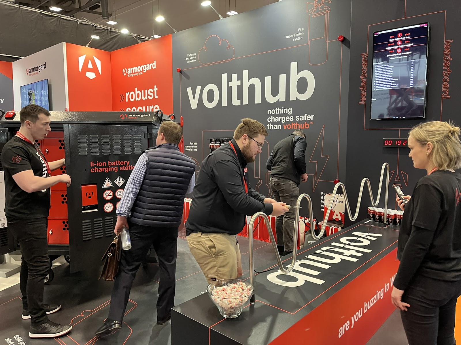 A person playing a game where they have to get a metal ring through a winding metal pole without the ring touching the pole