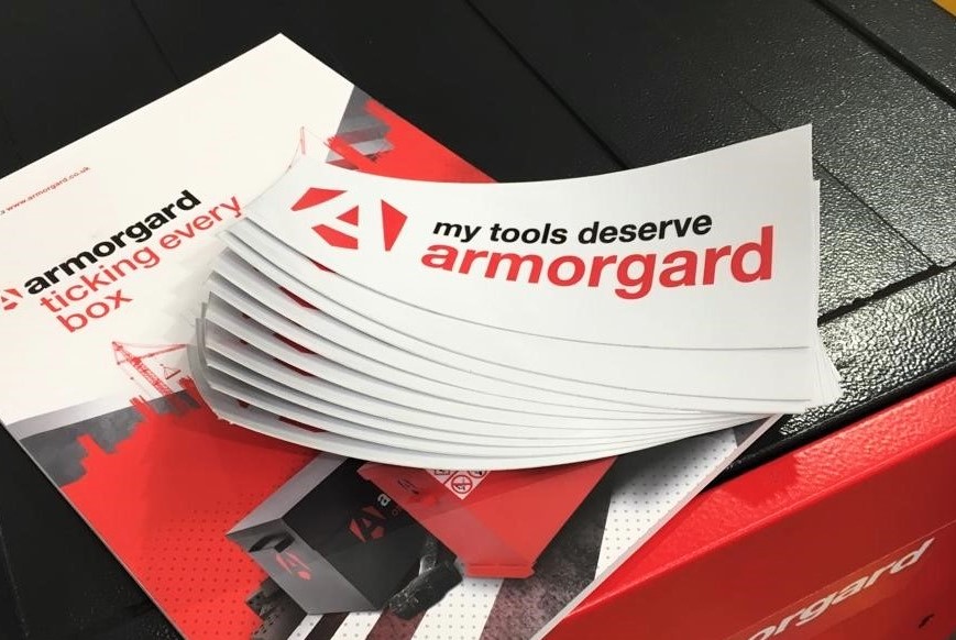 A armorgard magazine on top of an armorgard storage container which also has some Armorgard leaflets on top of the magazine