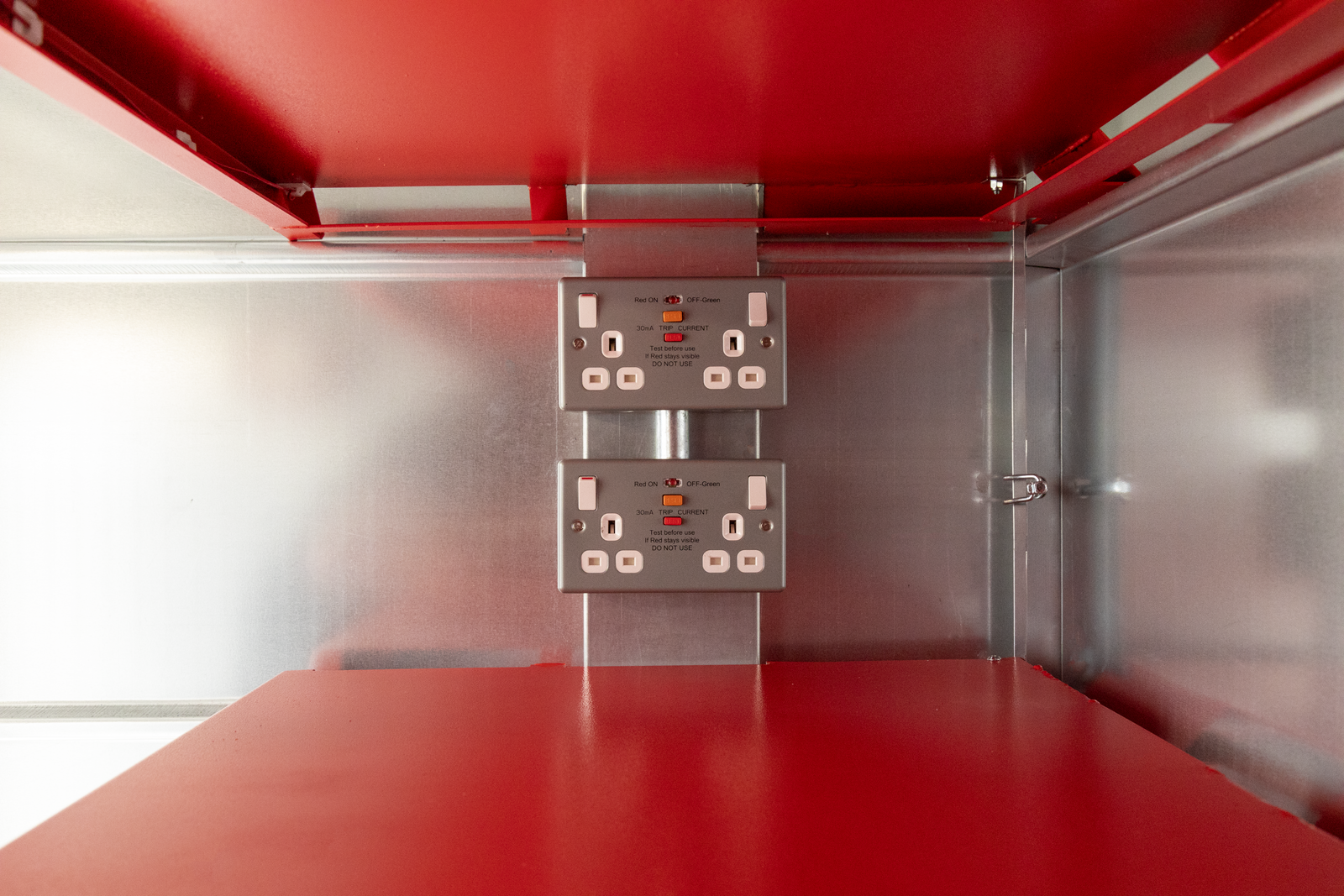 Close up of one of the power outlets that is located in between shelves in on of the Armorgard storage units